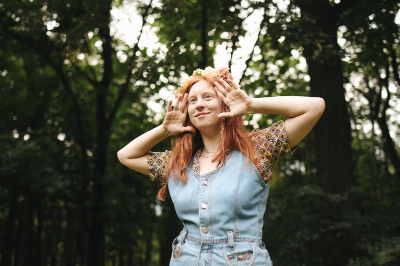 Smiling woman in a denim dress in nature
