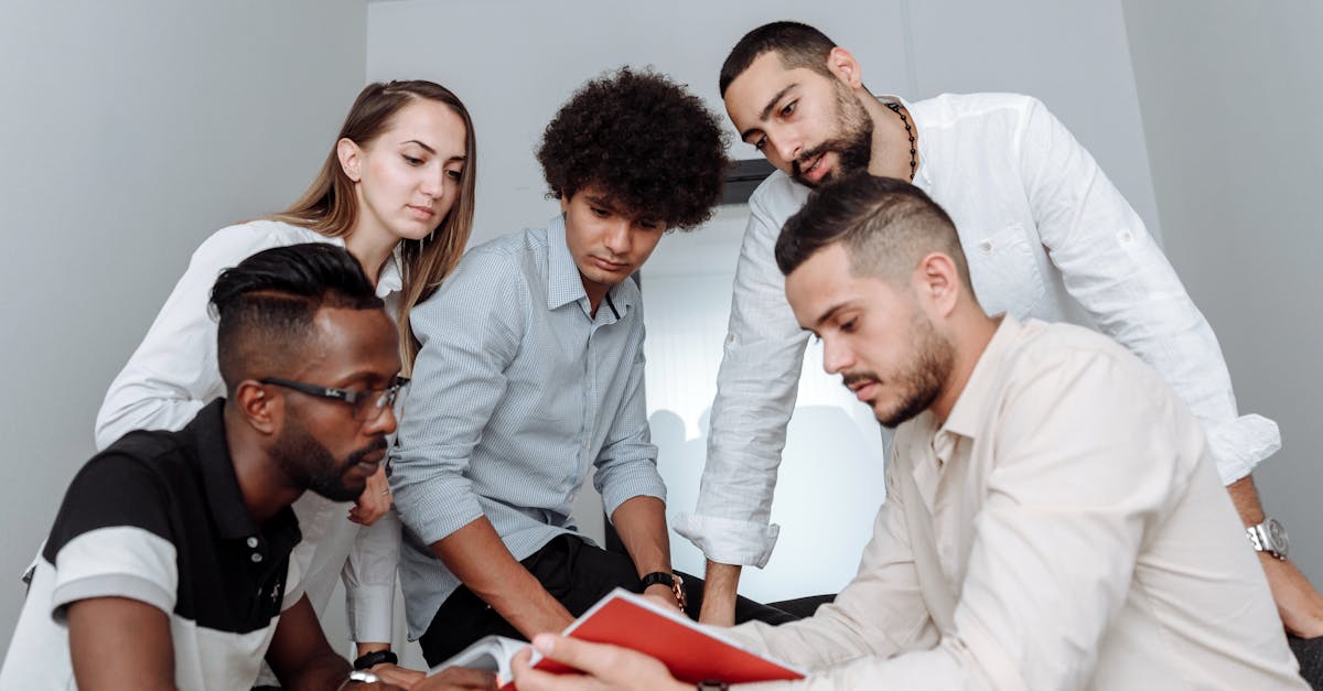 A multicultural team engaged in a collaborative office meeting, discussing ideas around a table.