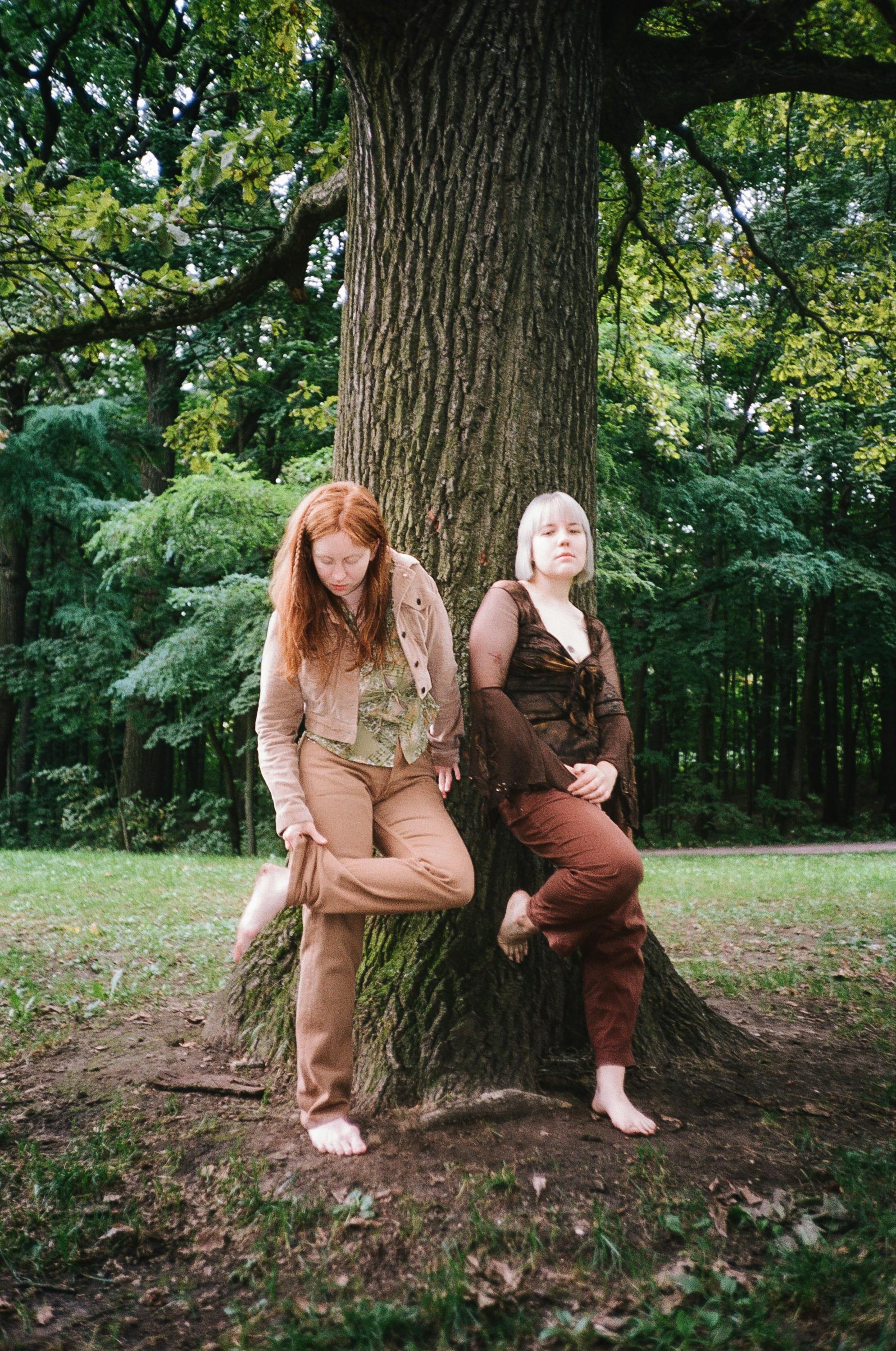 women standing beside the tree