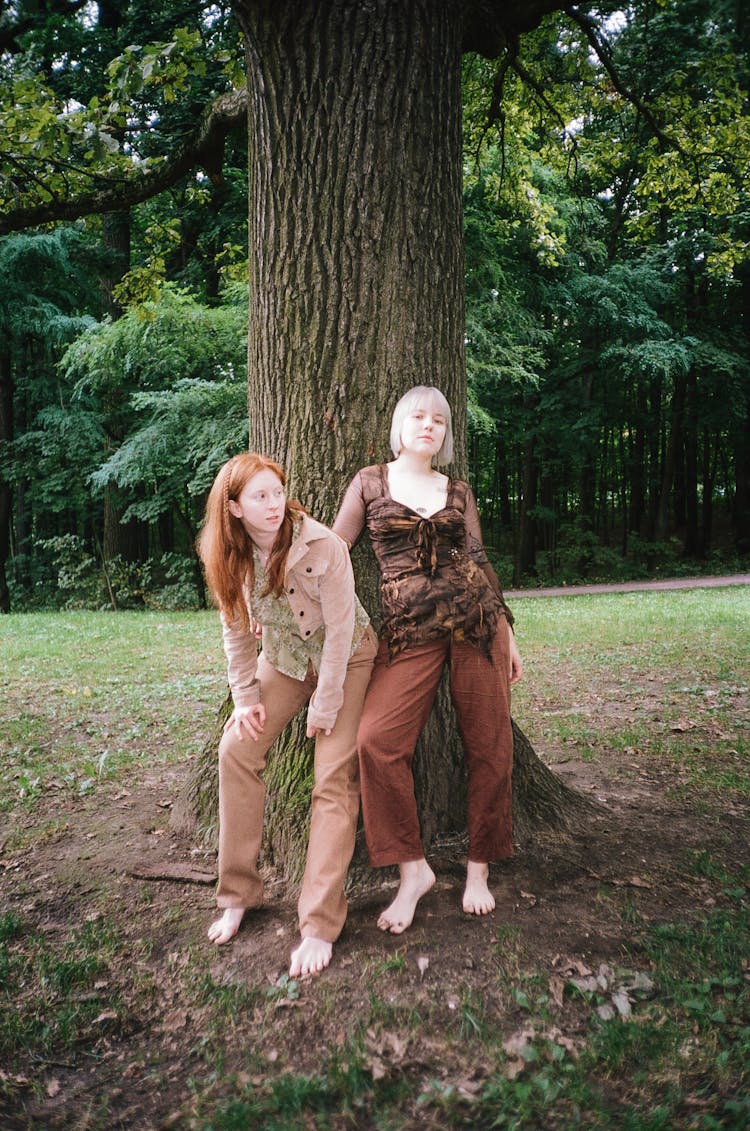 Women Posing Beside The Tree