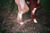 两个人赤脚站在树上，用泥土的音调展示他们的脚