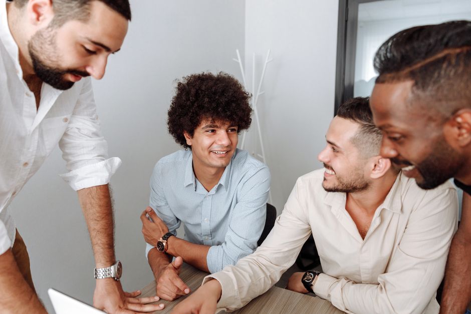Diverse group of men collaborating in modern office setting, engaging in a productive meeting. Diverse group of men collaborating in modern office setting, engaging in a productive meeting.