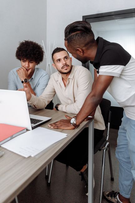Three men engaged in a collaborative business meeting indoors, discussing ideas. Three men engaged in a collaborative business meeting indoors, discussing ideas.