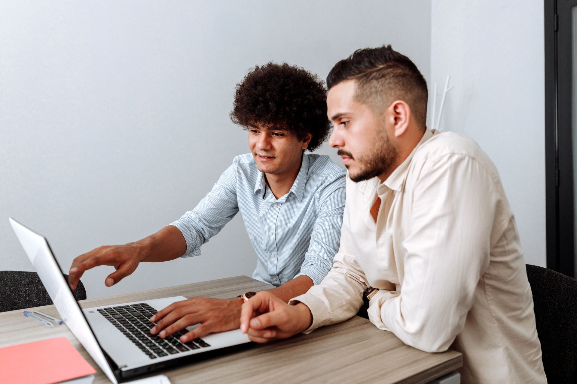 Men using Laptop while Working Together