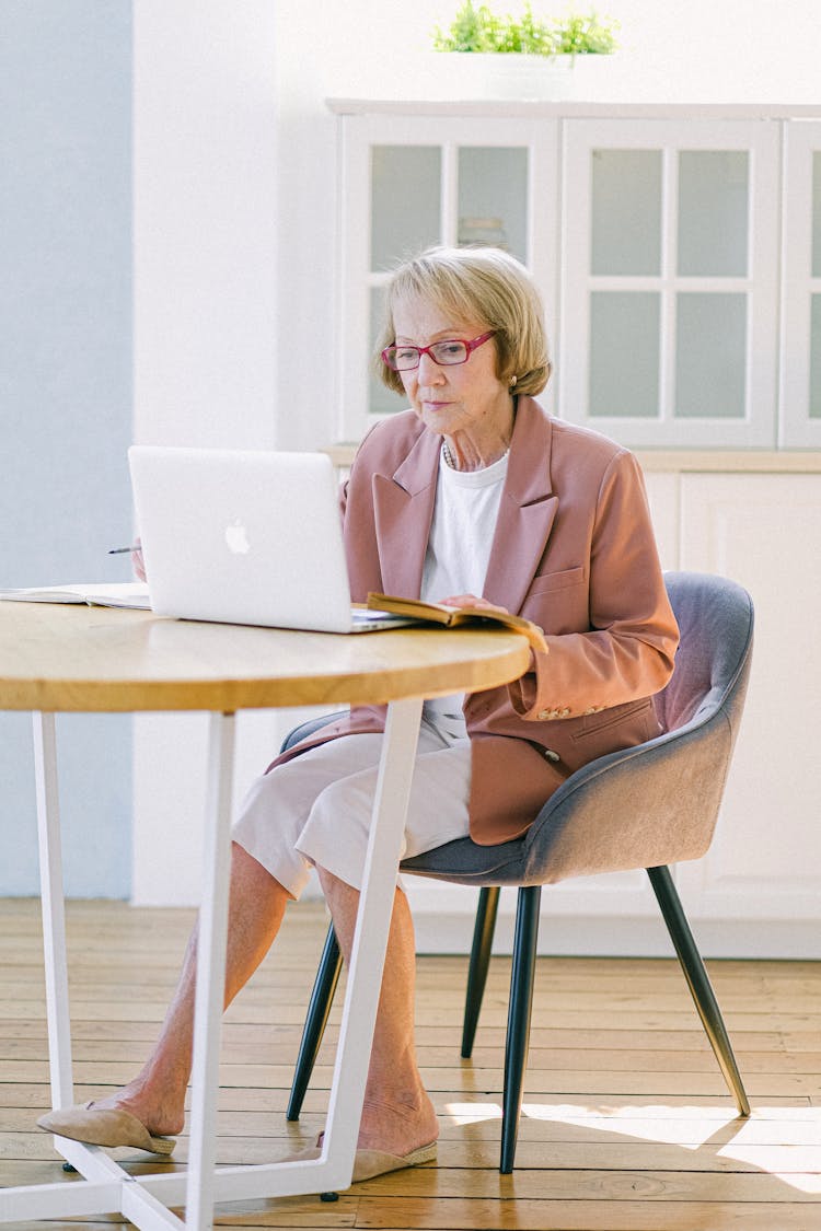 Senior Experienced Woman In Eyeglasses Working With Laptop