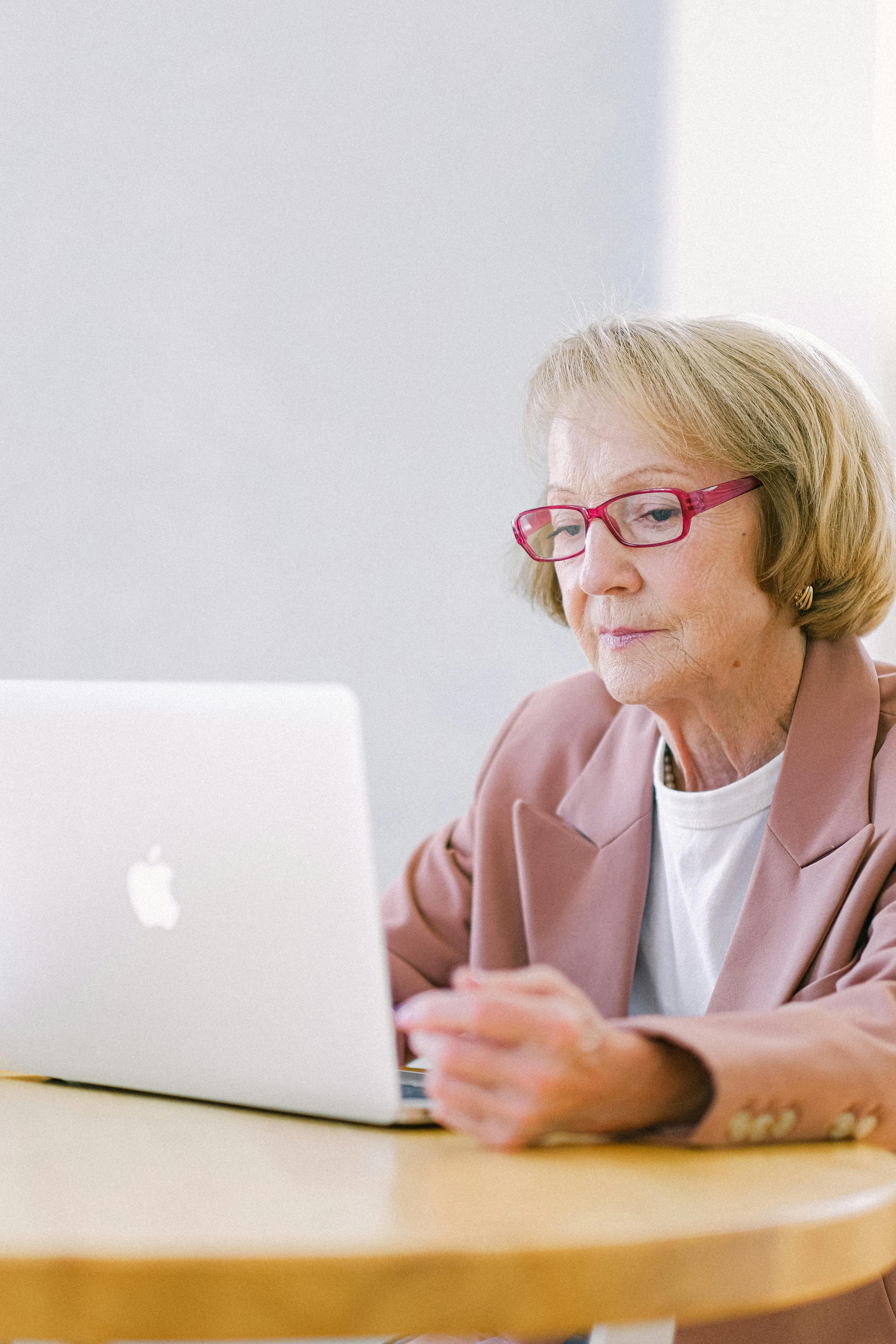 serious senior woman creating business project on laptop