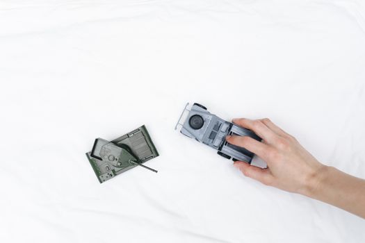 A hand interacts with toy vehicles on a white background, offering ample copy space.