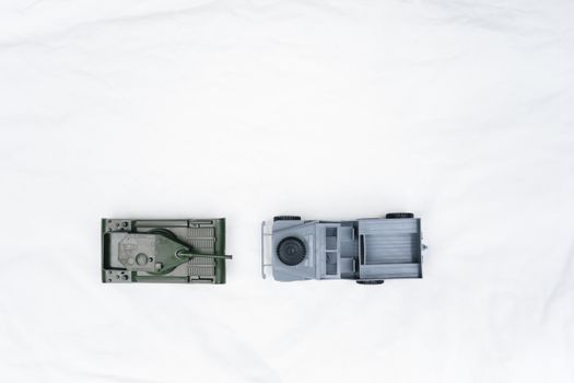 Aerial photo of toy tank and jeep models on a white backdrop, ideal for model enthusiasts.