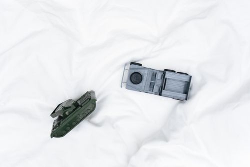 Free Toy tank and jeep miniatures displayed against a soft white backdrop for military-themed collections. Stock Photo