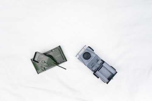 Free Aerial perspective of military toy vehicles, including a tank and jeep, on a white background. Stock Photo