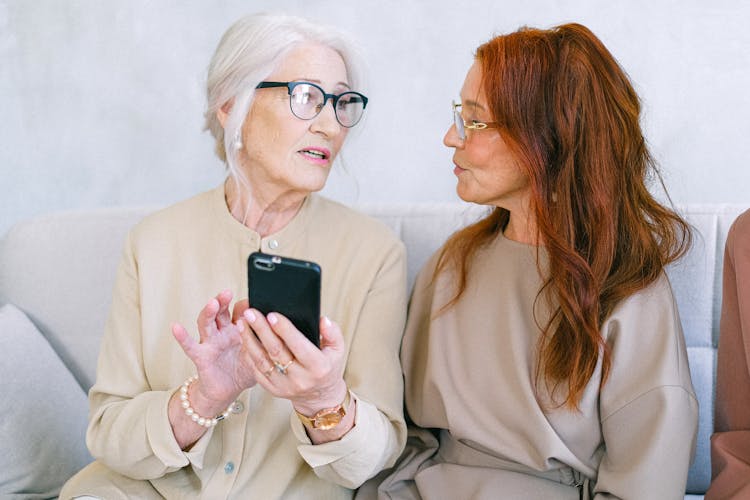 Senior Women Communicating And Using Smartphone