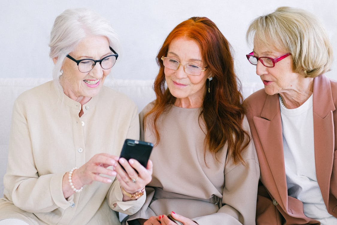 Free Senior happy women watching video online in smartphone Stock Photo