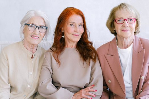 Aged cheerful women in elegant outfit together