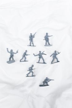 Detailed view of gray plastic toy soldiers arranged on a white backdrop.