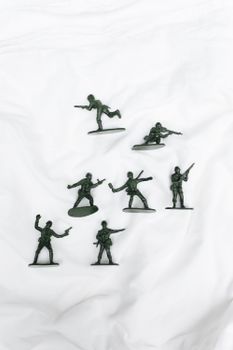 A collection of green plastic toy soldiers arranged on a white background.