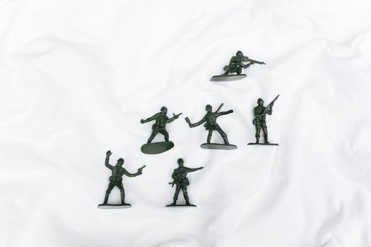 Aerial view of green plastic toy soldiers on a textured white surface, ideal for toy collections.