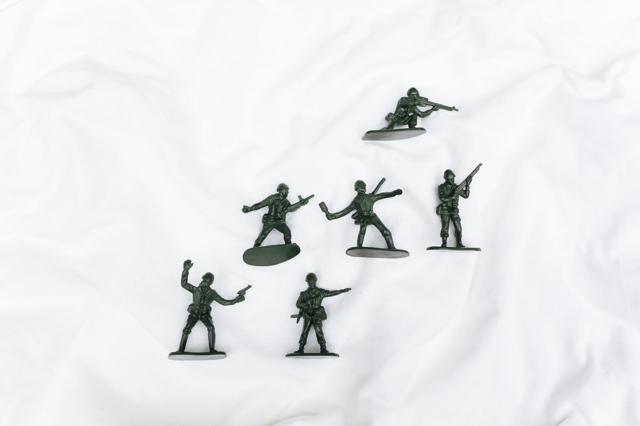 aerial view of green plastic toy soldiers on a textured white surface