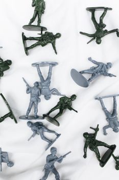 Detailed close-up of plastic toy soldiers in green and gray on a white background.