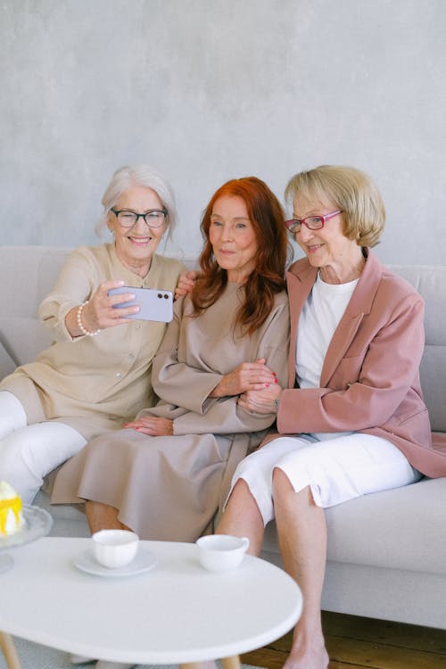 Free Aged women taking selfie with smartphone at table with cups Stock Photo