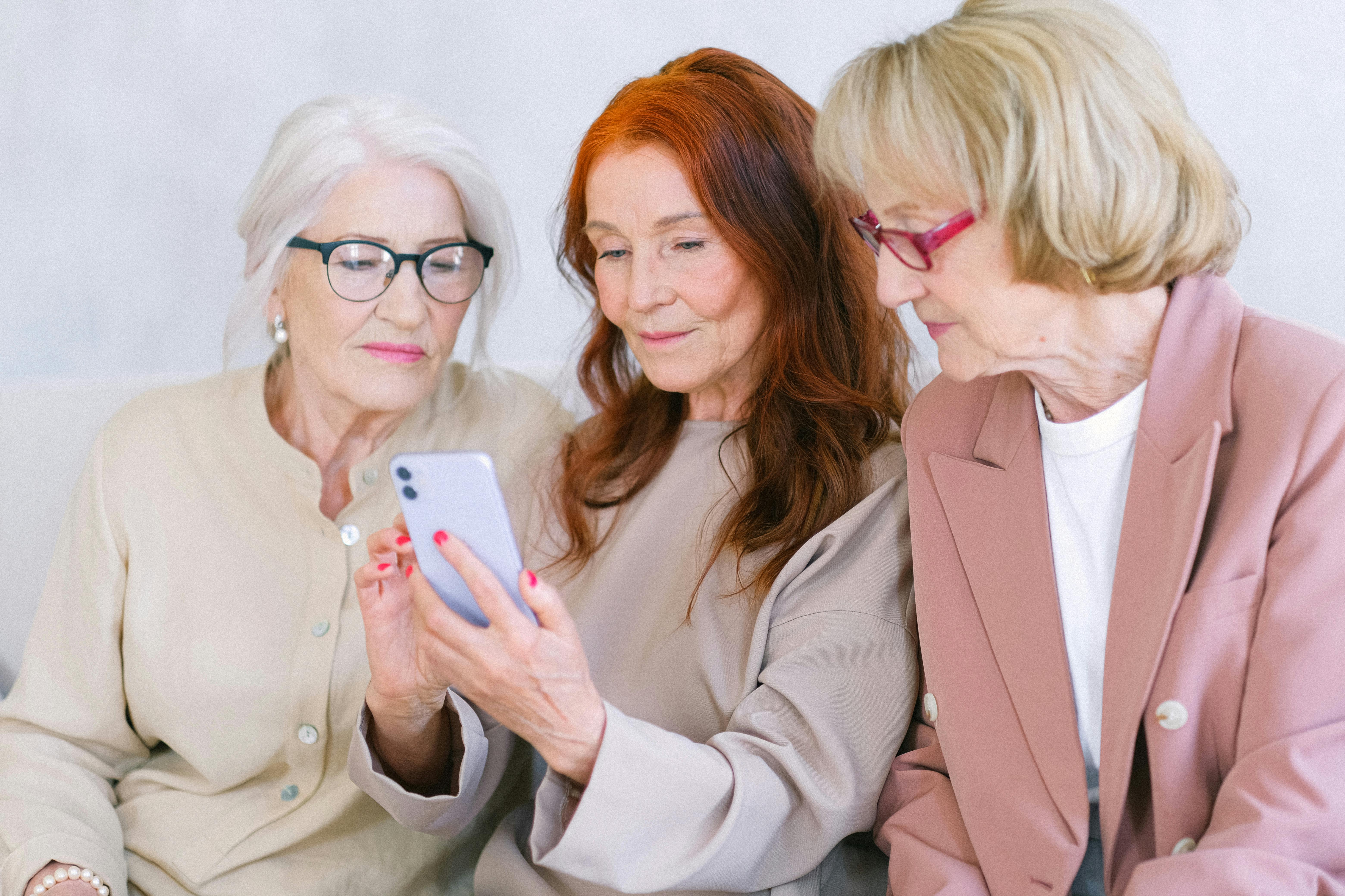 aged women using smartphone together