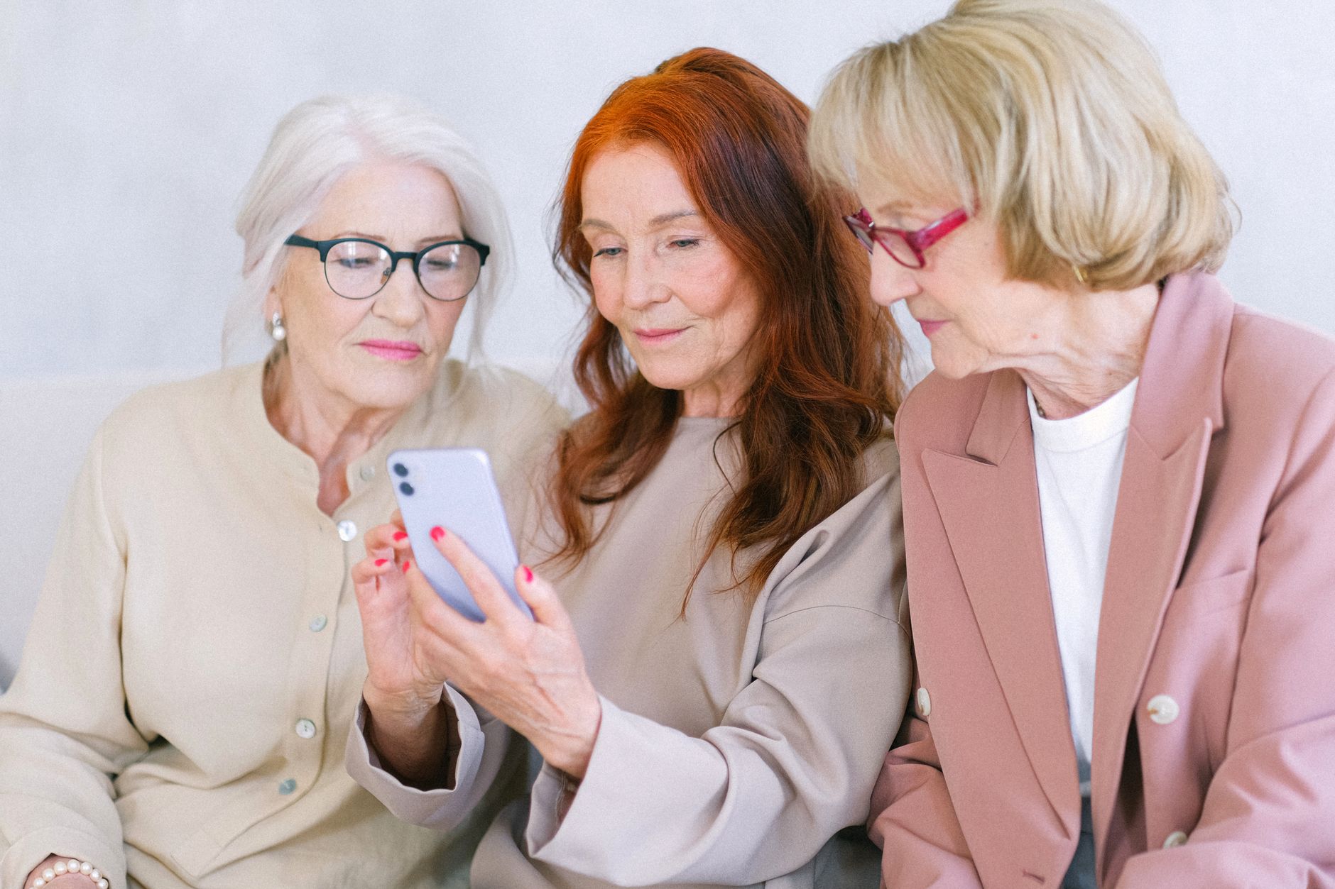 대전 어르신 스마트폰 무료 교육, 구청·평생교육원 신청처 이렇게 찾는다 2 Three senior women browsing a smartphone together, showcasing connection and technology use.