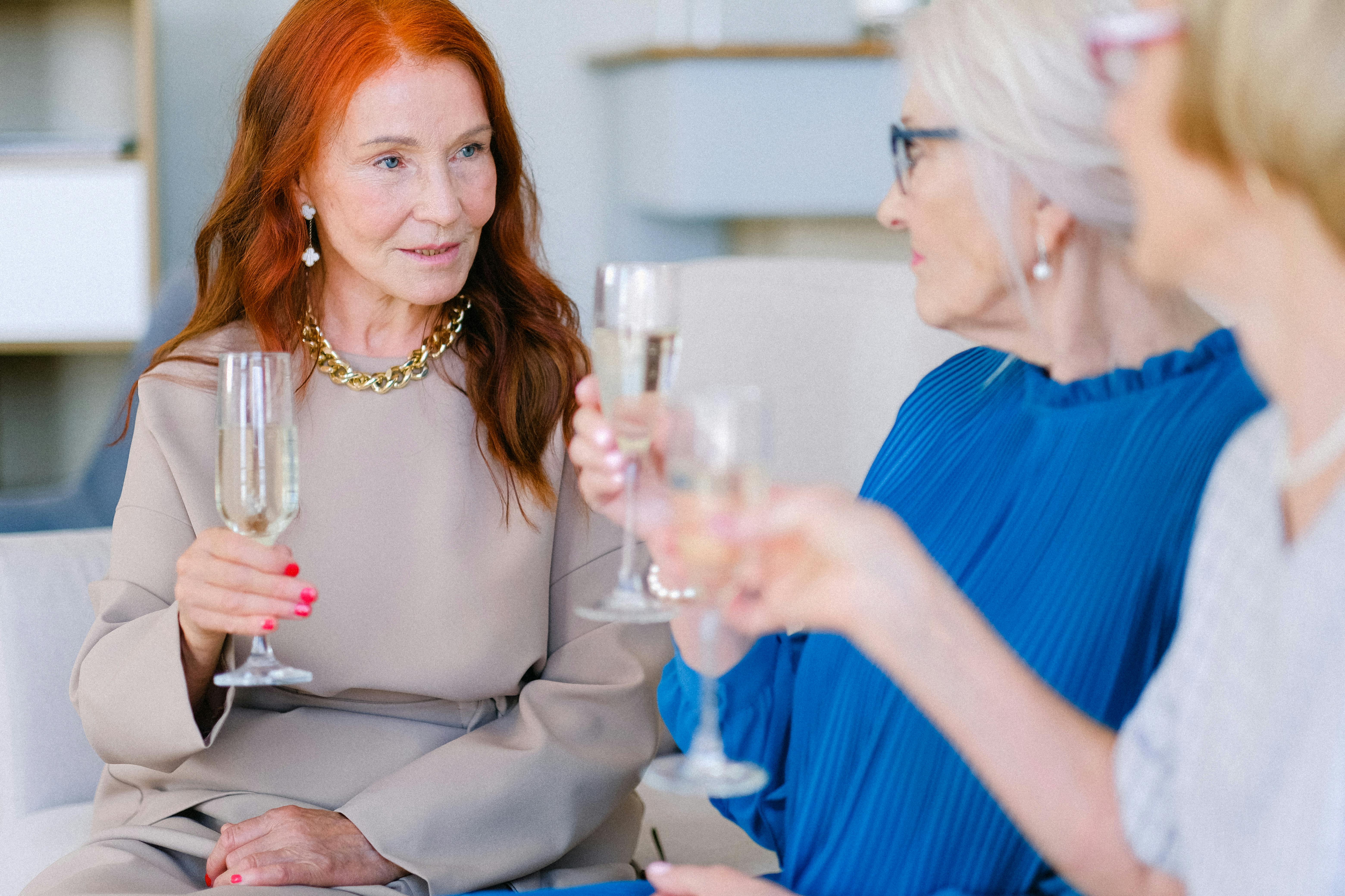 senior women with glasses of champagne talking