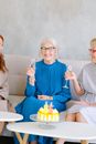 三位女士在室内享用香槟和蛋糕庆祝生日