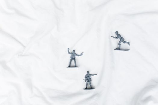 Plastic toy soldiers arranged creatively on a white background, offering ample copy space.