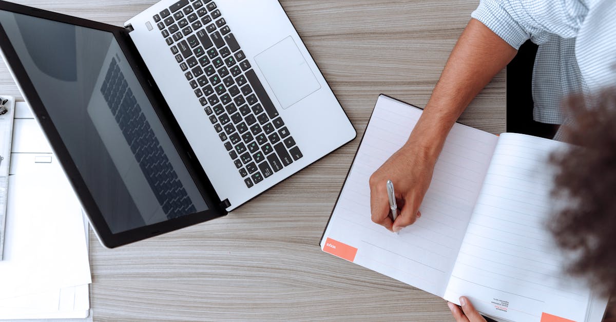 Person Holding White Paper on Brown Wooden Table