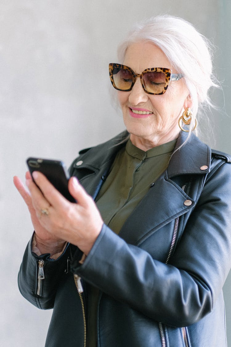 Stylish Elderly Woman In Trendy Jacket Checking Smartphone