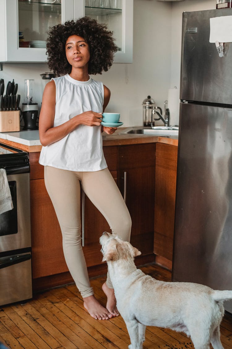 Dreamy Woman With Coffee And Pet In Kitchen