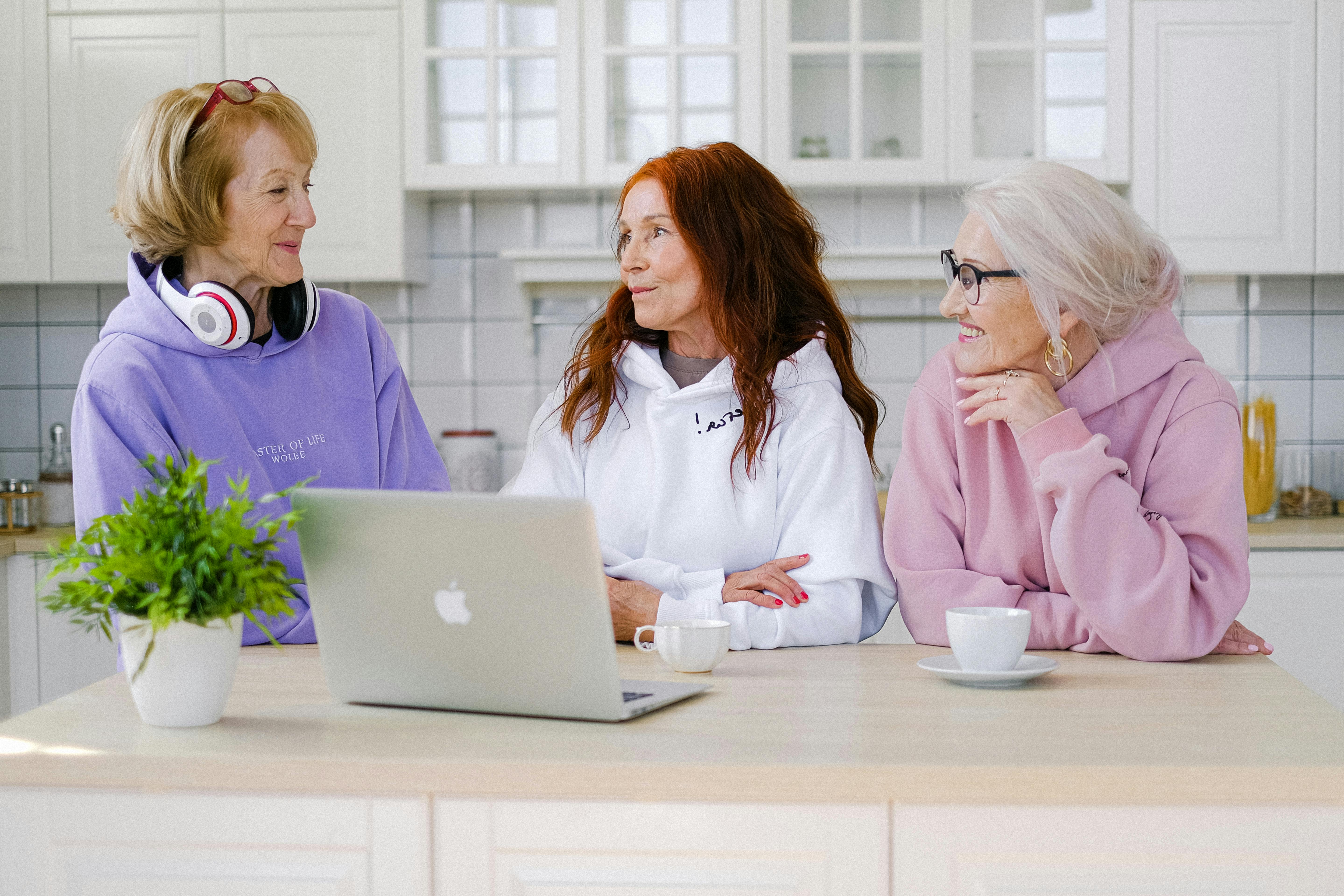 positive senior women standing at table in kitchen and communicating