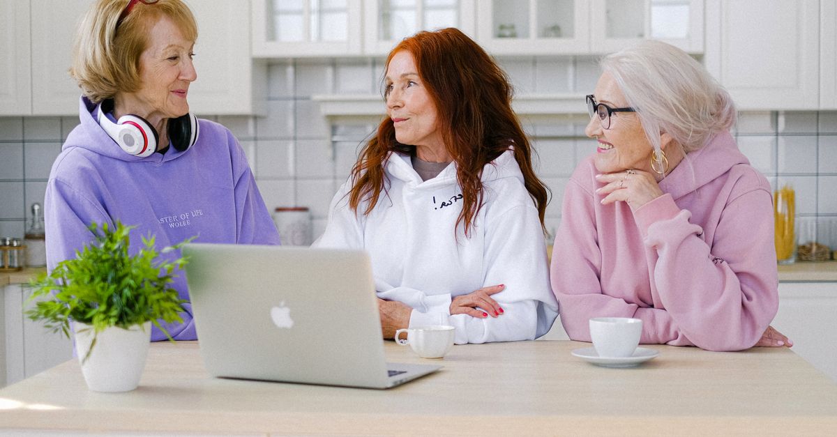 Three senior women enjoying warm coffee and conversation.