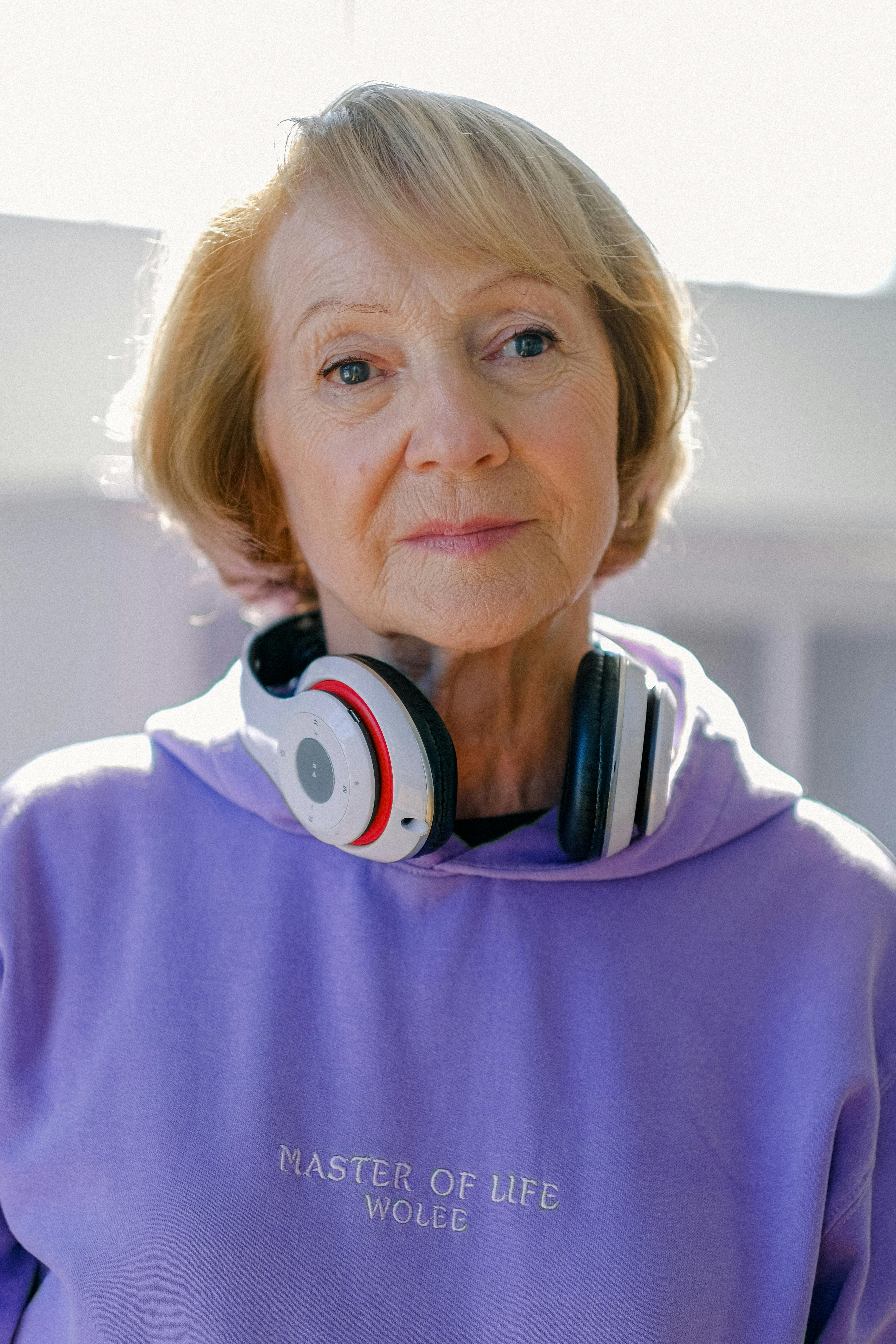 calm senior woman with headphones looking away