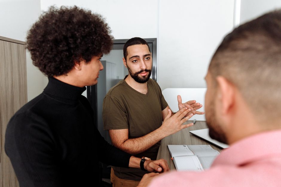 Group of colleagues having a thoughtful discussion in a modern office setting.