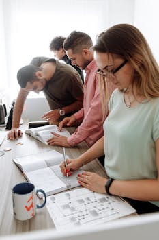 Group of young professionals collaborating on a project in a modern office setting.