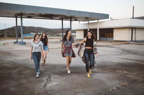 Four Women Walking in Station Under Clear Sky