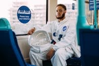 一名穿着太空服的男子在伦敦乘坐公共交通工具，营造出独特而奇异的场景