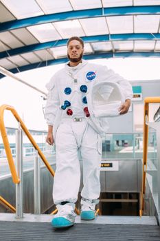 一名穿着太空服的男子在地铁站手持头盔