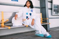 一名穿着太空服的女人坐在地铁站里，将太空主题与城市生活融为一体