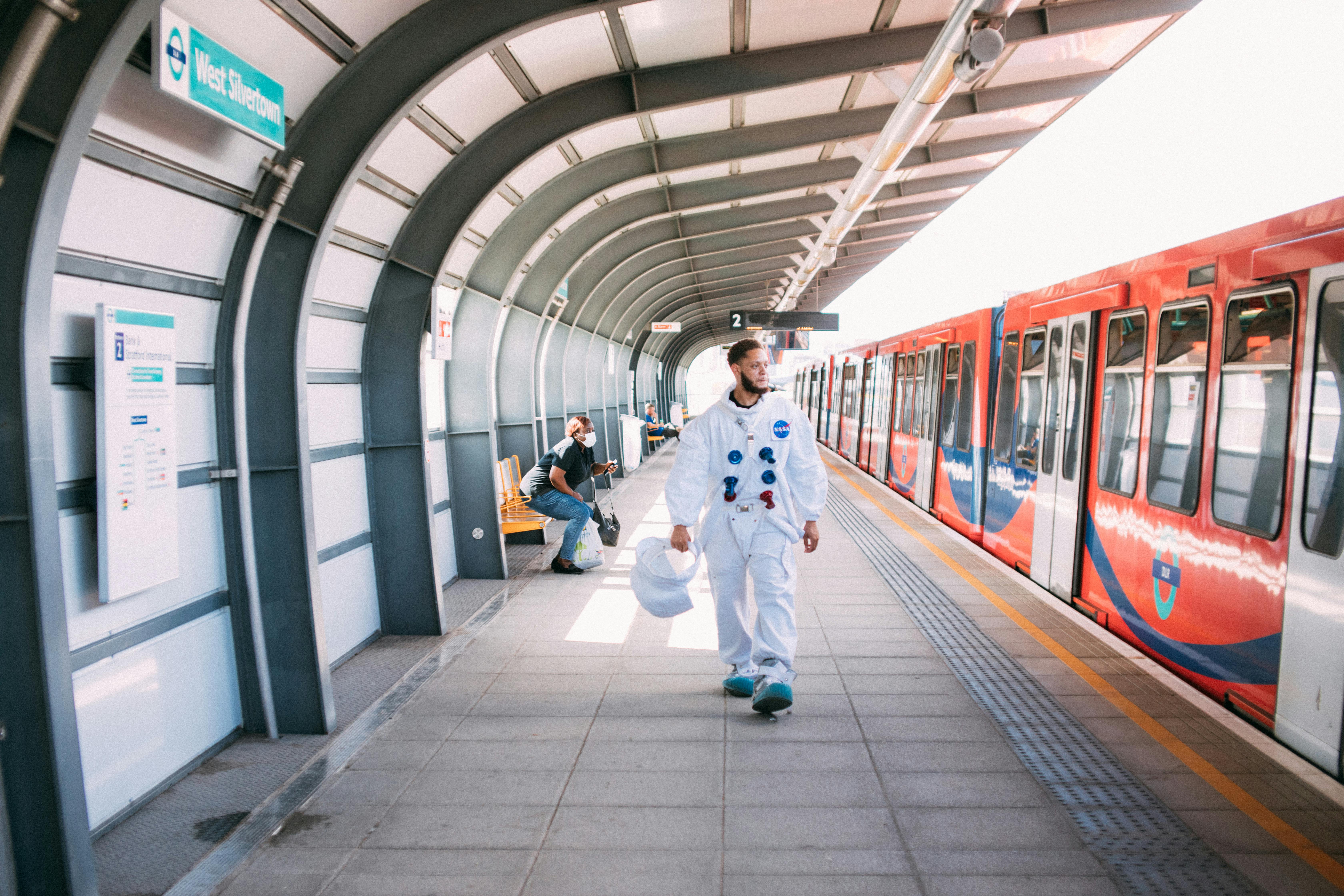 Man in astronaut costume at West Silvertown DLR station, London.