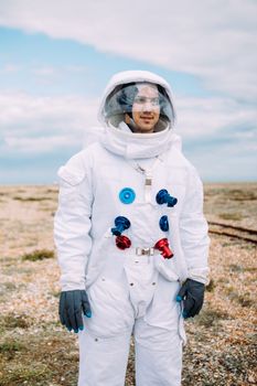 一位穿着宇航员服装的成年人在风景优美的户外摆姿势