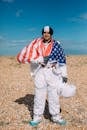 一个男人打扮成宇航员，裹着美国国旗站在户外