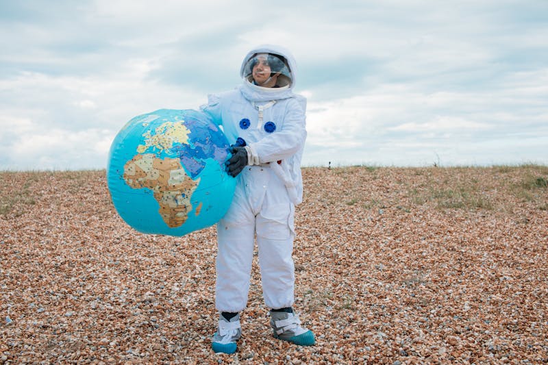 a woman in astronaut dress holding earth