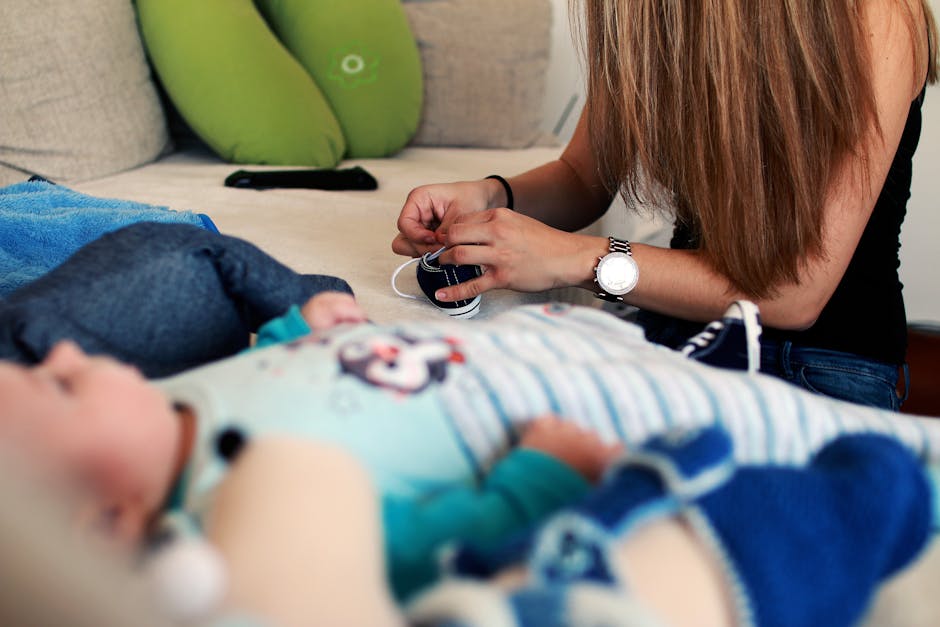 Woman Tieing Shoe Near Baby in Blue Stripe Onesie