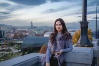 Woman in Black and White Coat Sitting on Gray Concrete Bench