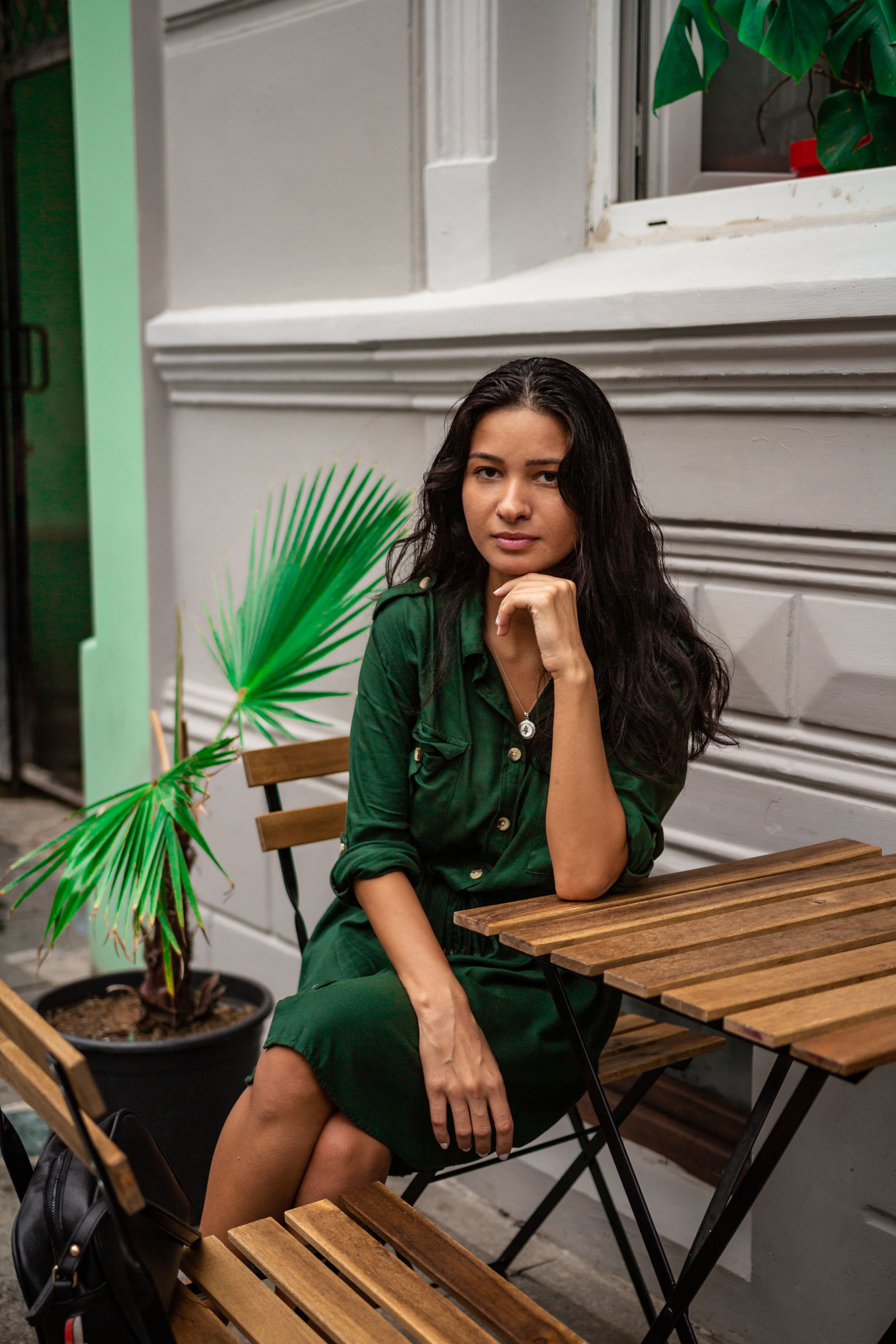 A Woman in a Green Dress Sitting on a Chair  Free Stock Photo