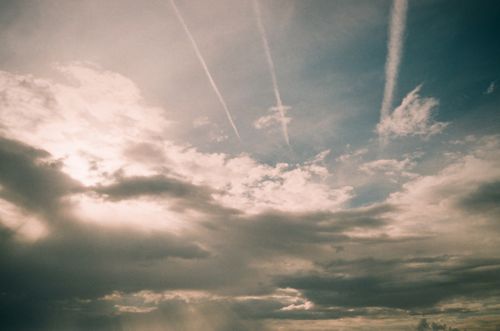 Free An atmospheric sky scene with dramatic clouds and jet contrails on a bright day. Stock Photo