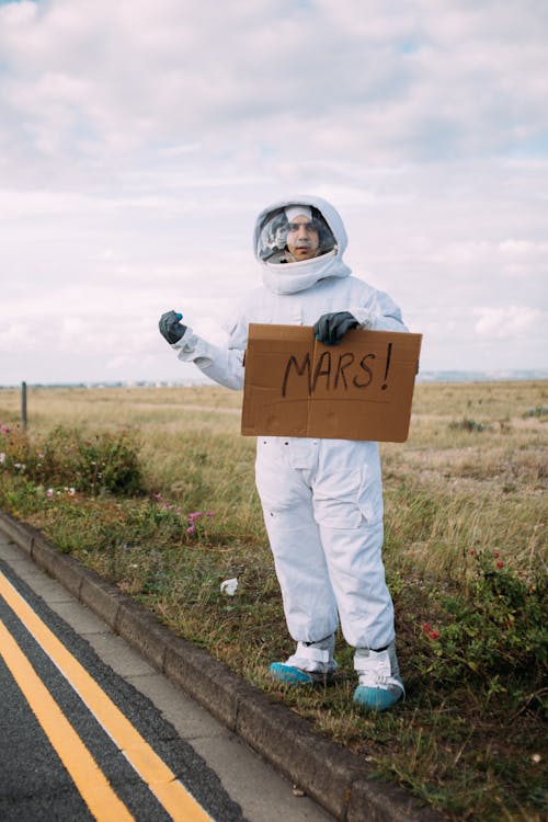 Free Man In A Space Suit Hitchhiking Stock Photo