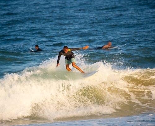 Man in Black Shirt Surfing on Sea Waves
